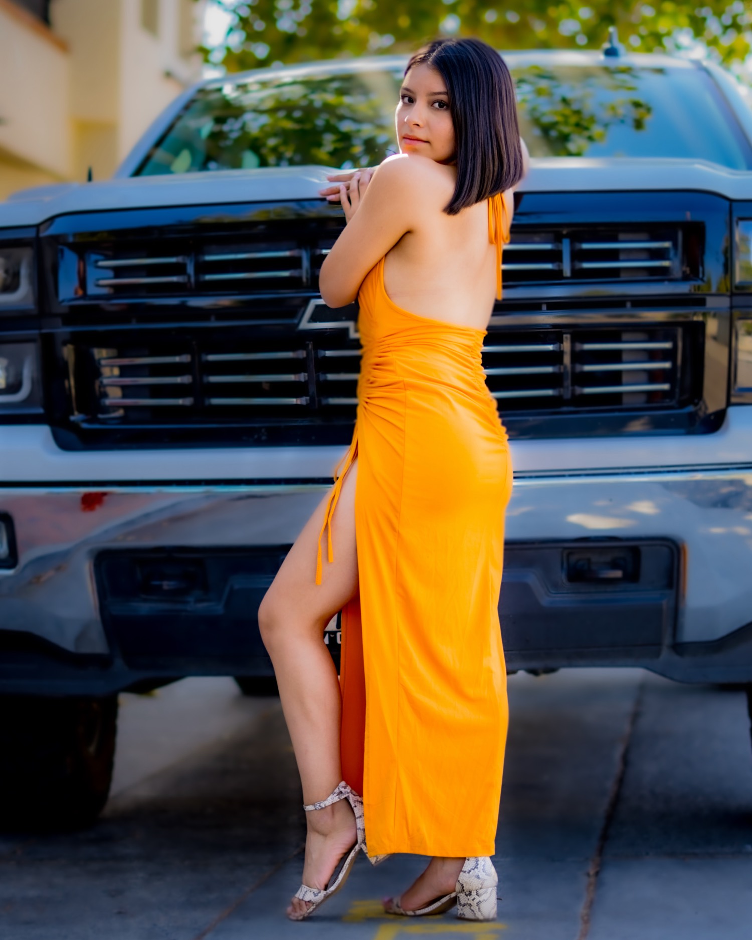 Portrait in an orange dress against a truck