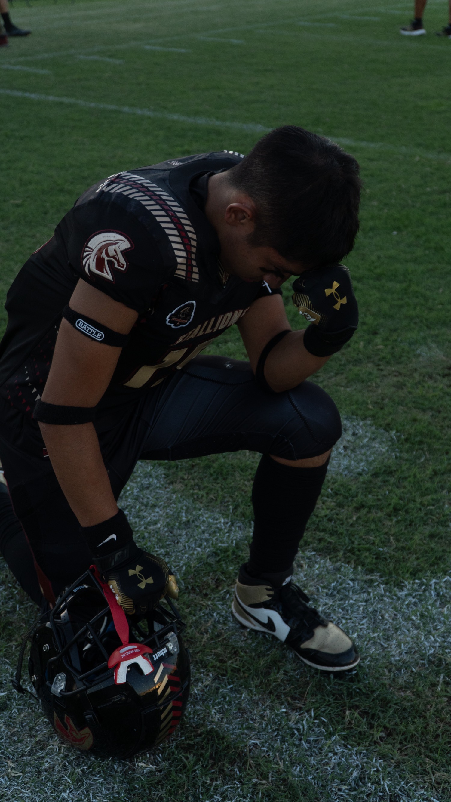 Player kneeling with helmet after the game