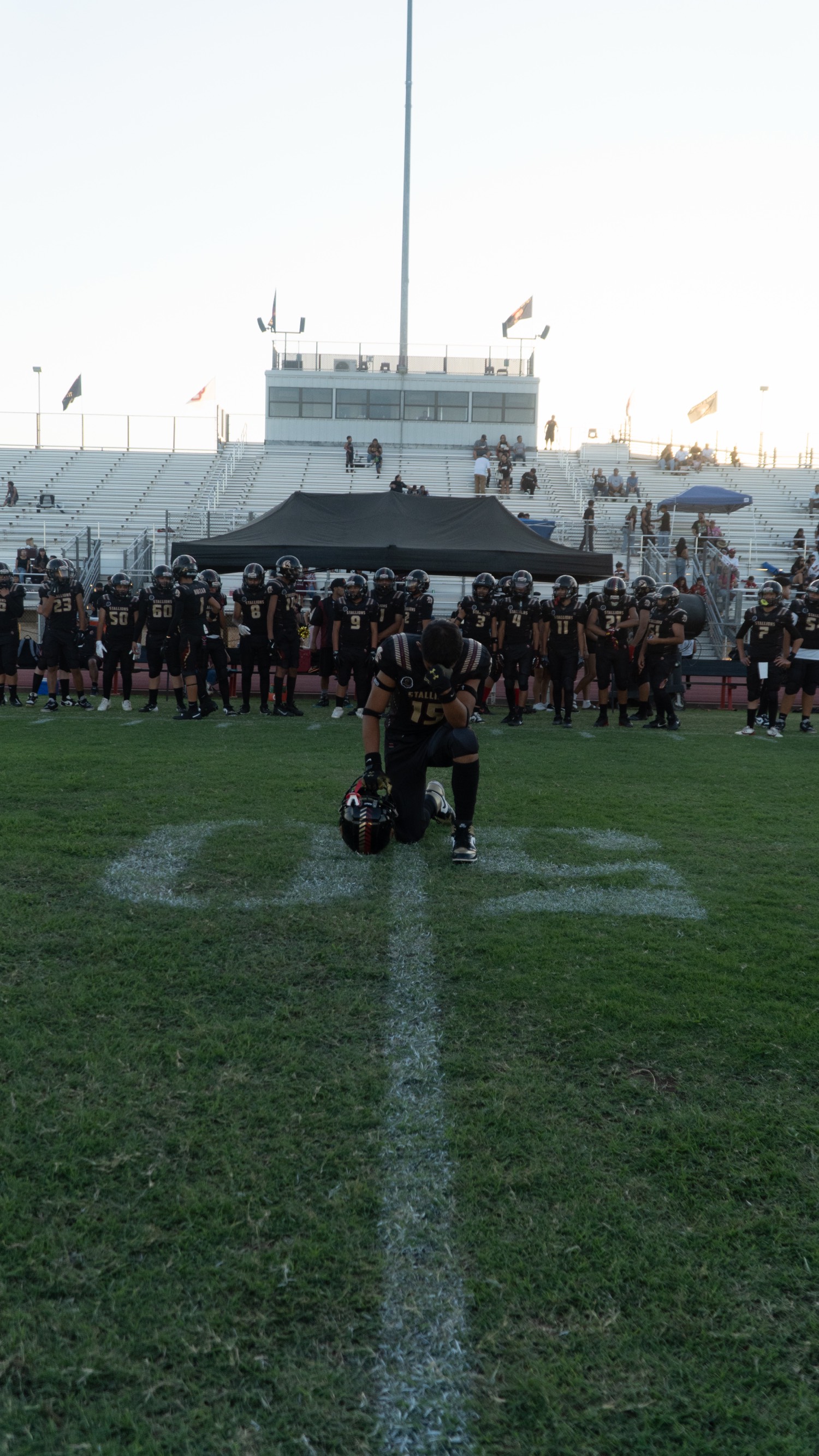 Player kneeling on the 50-yard line
