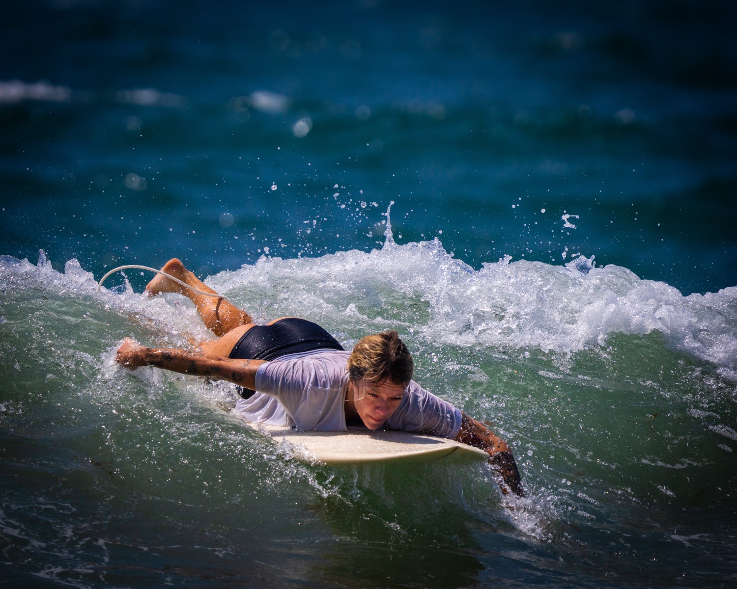 Surfer paddling through whitewater